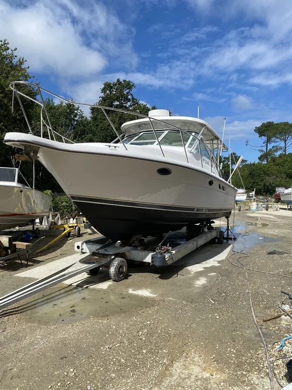 Un bateau à cabine sur sa remorque, au terrain du chantier