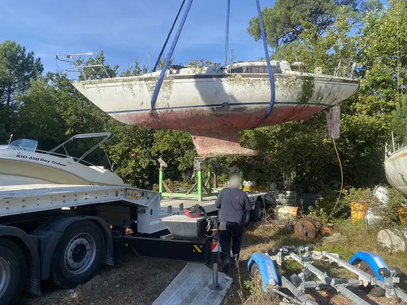 Le voilier levé à la grue au-dessus du camion