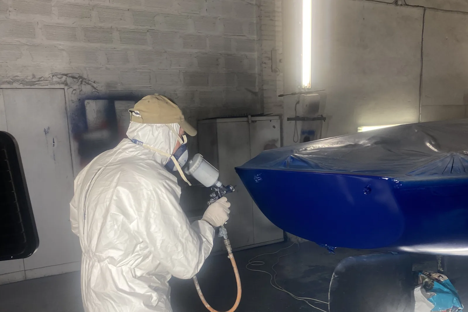 une coque repeinte au pistolet après un sinistre, en cabine de peinture